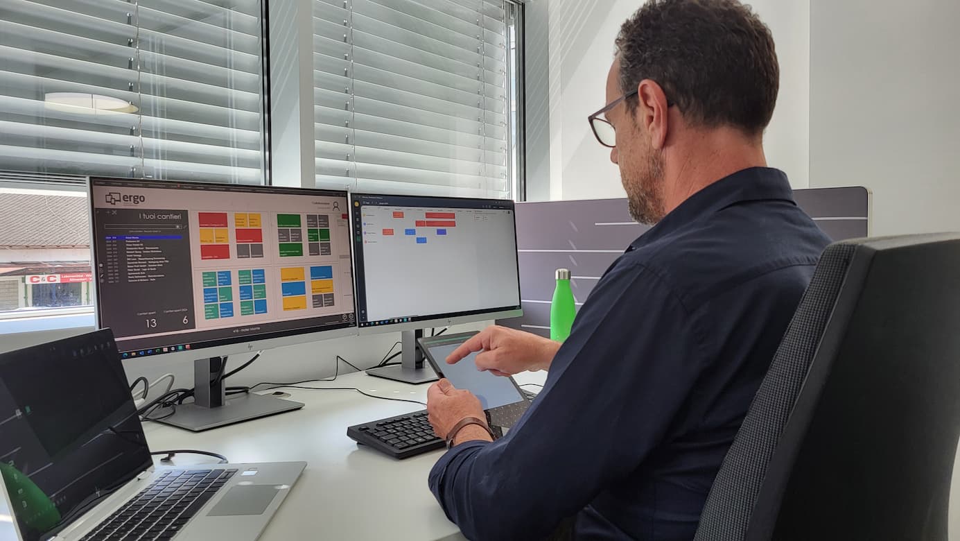 Team di una PMI che lavora con software ERP da computer e tablet